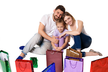 Image showing Happy family with shopping bags sitting at studio 