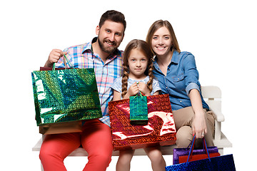 Image showing Happy family with shopping bags sitting at studio 