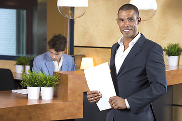 Image showing Businessman Holding Documents At Reception Counter