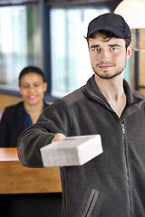 Image showing Delivery Man Giving Package In Office