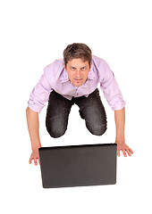 Image showing Man kneeling in front of laptop.