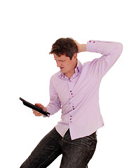 Image showing Man wondering what is on his tablet pc.