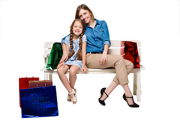 Image showing Happy a mother and daughter with shopping bags sitting at studio 