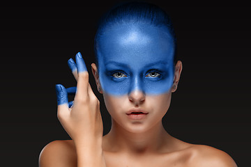 Image showing Portrait of a woman who is posing covered with blue paint