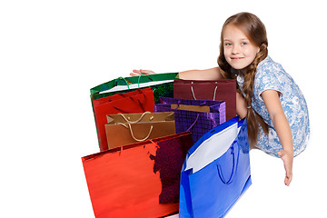 Image showing Happy girl with shopping bags sitting at studio 