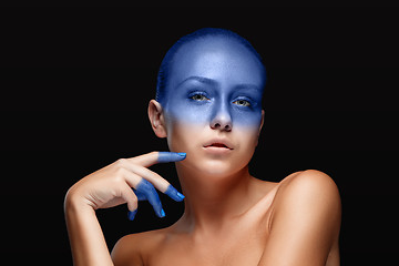 Image showing Portrait of a woman who is posing covered with blue paint