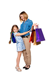 Image showing Happy  mother and daughter with shopping bags standing at studio 