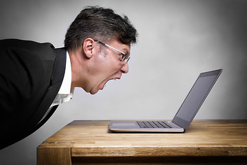 Image showing Man screaming at laptop