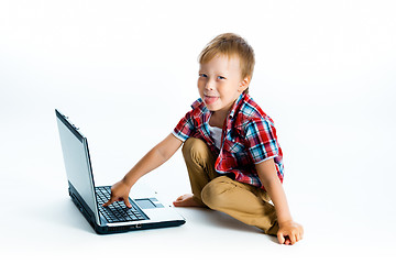 Image showing boy in a plaid shirt with a laptop on a white background.