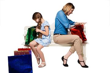 Image showing Happy  mother and daughter with shopping bags sitting at studio 