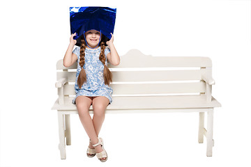 Image showing Happy girl with shopping bags sitting at studio 