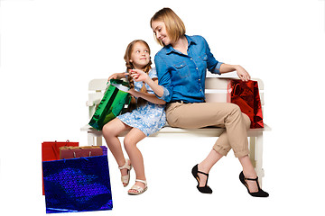 Image showing Happy  mother and daughter with shopping bags sitting at studio 