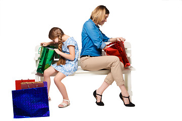 Image showing Happy  mother and daughter with shopping bags sitting at studio 