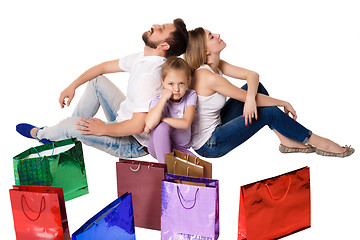 Image showing Happy family with shopping bags sitting at studio 