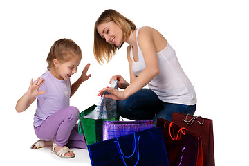 Image showing Happy a mother and daughter with shopping bags sitting at studio 