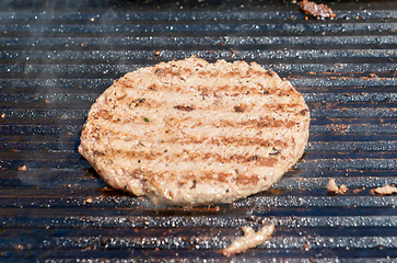 Image showing succulent grilled steak on hot grill