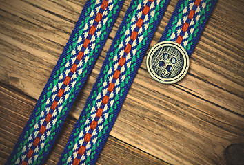 Image showing vintage ribbon with embroidered ornament and old classic button