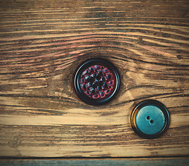 Image showing two vintage buttons on aged wood surface