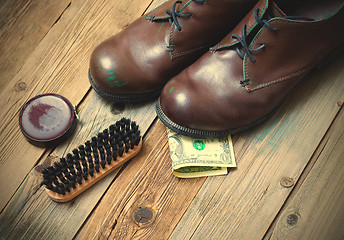 Image showing boots, brush, shoe polish and dollar