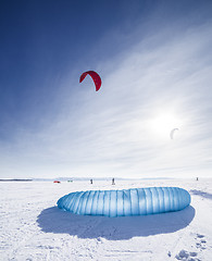 Image showing Kiteboarder with blue kite on the snow