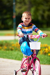 Image showing happy boy learning to ride his first bike