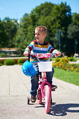 Image showing happy boy learning to ride his first bike