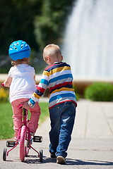 Image showing Boy and girl in park learning to ride a bike