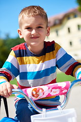 Image showing happy boy learning to ride his first bike