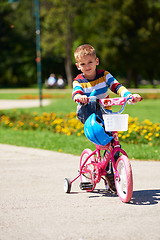 Image showing happy boy learning to ride his first bike