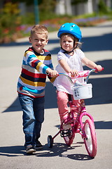 Image showing Boy and girl in park learning to ride a bike