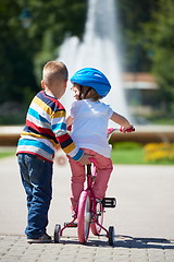 Image showing Boy and girl in park learning to ride a bike