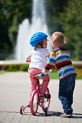 Image showing Boy and girl in park learning to ride a bike