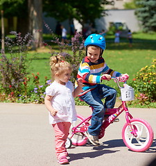 Image showing Boy and girl in park learning to ride a bike