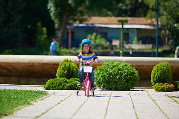 Image showing happy boy learning to ride his first bike