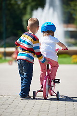 Image showing Boy and girl in park learning to ride a bike