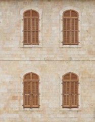 Image showing Wall of the old building with closed windows covered by wooden blinds