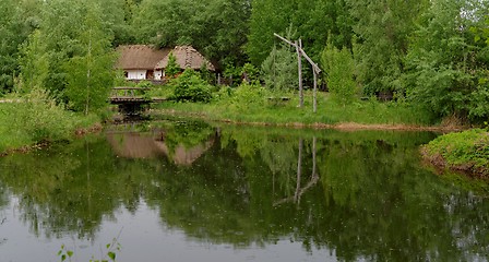 Image showing Traditional farmer's house reflecting in a pond in open air museum, Kiev, Ukraine