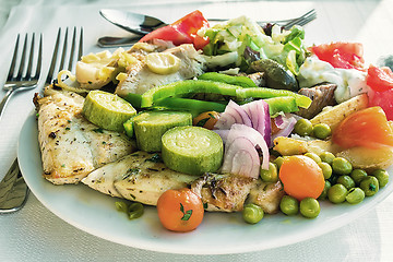 Image showing Meat, fish and various vegetable garnish on a plate.