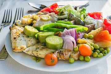 Image showing Meat, fish and various vegetable garnish on a plate.