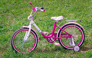 Image showing The bicycle for the girl on a green lawn.