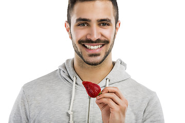 Image showing Happy young eating a strawberry