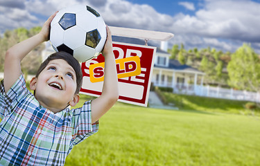 Image showing Boy Holding Ball In Front of House and Sold Sign