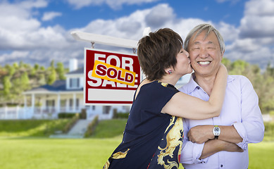 Image showing Affectionate Senior Chinese Couple In Front of House and Sign