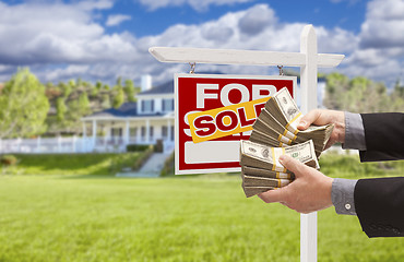 Image showing Man Handing Over Money in Front Sold House and Sign