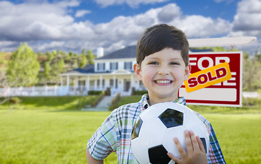 Image showing Boy Holding Ball In Front of House and Sold Sign