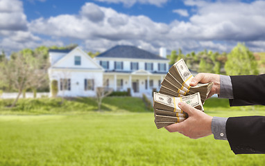 Image showing Man Handing Over Hundreds of Dollars in Front of House