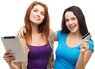 Image showing two smiling girls with tablet pc and credit card