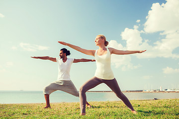 Image showing smiling couple making yoga exercises outdoors