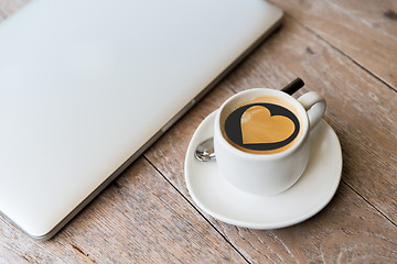 Image showing close up of laptop and coffee cup with heart shape