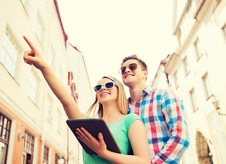 Image showing smiling couple with tablet pc in city